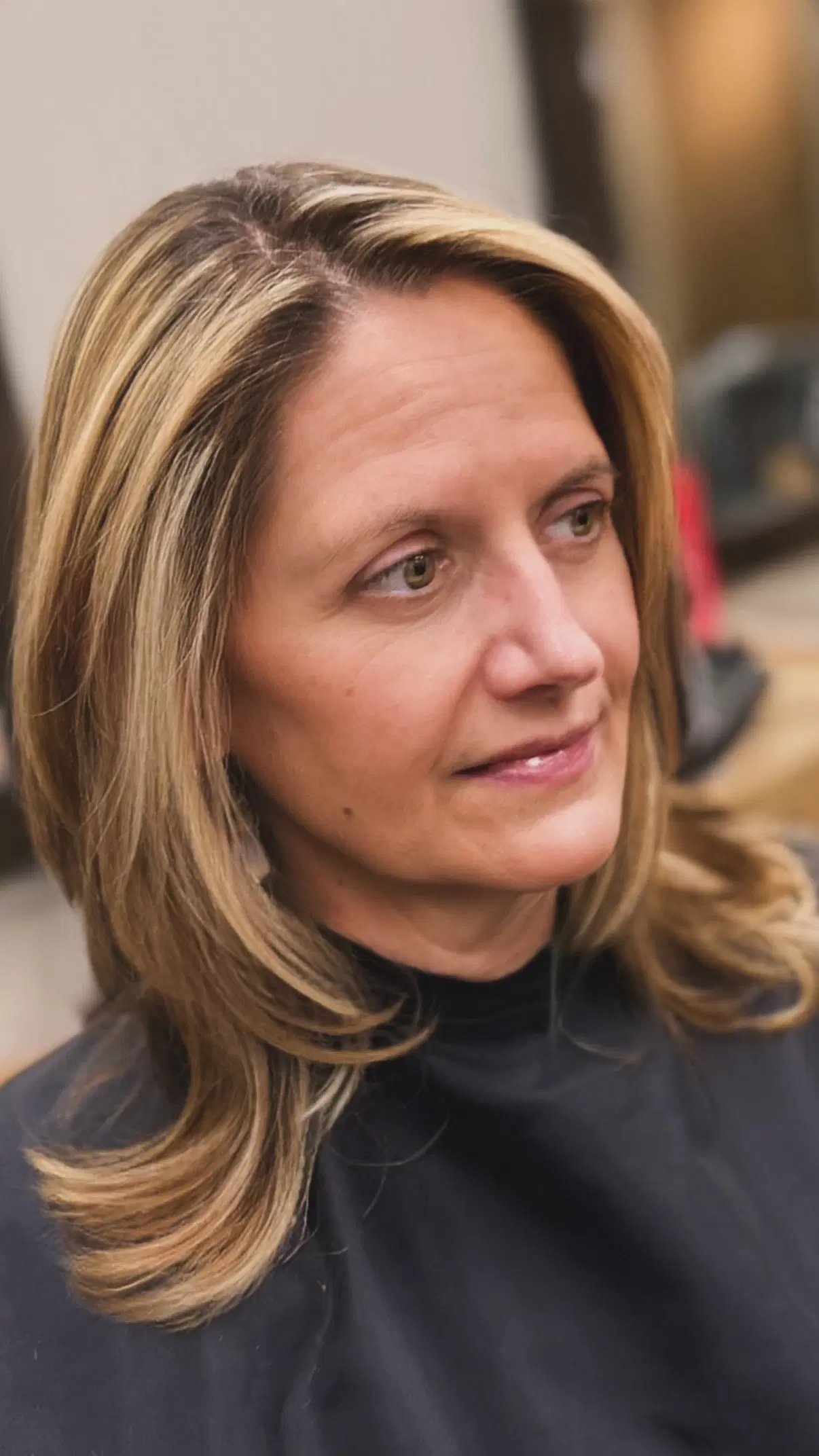 Shoulder-length hair with honey highlights, curled at the ends