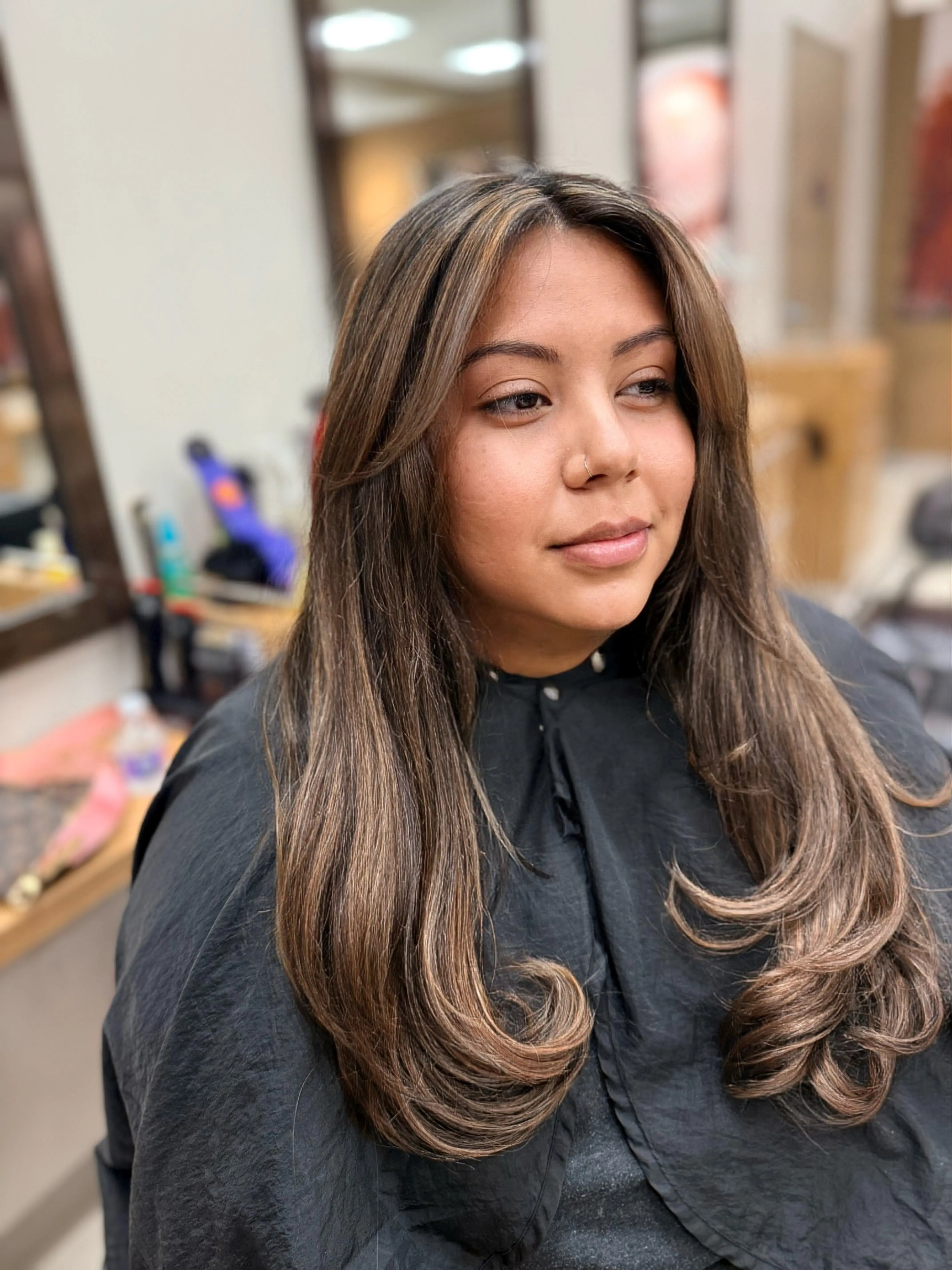 Long brunette hair with caramel balayage, finished in soft curls