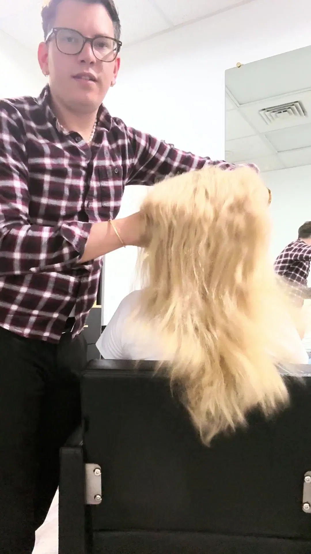 Brittle, over-lightened platinum hair before a color correction, held up by Rudy Perez
