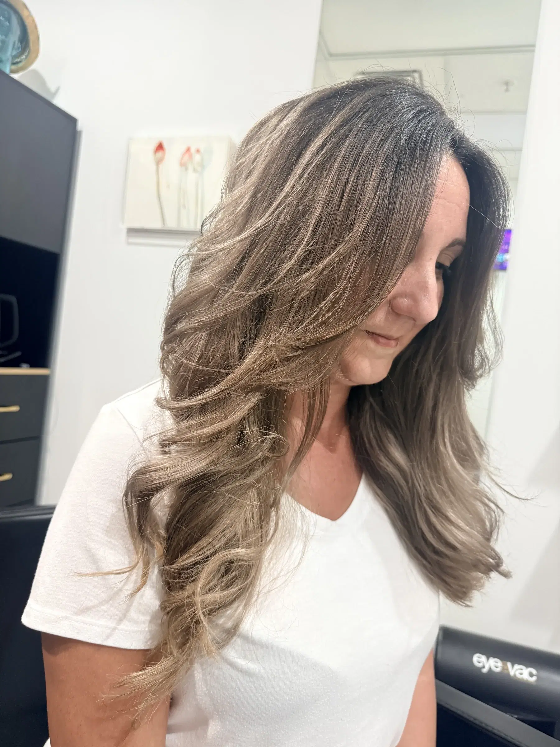 Soft, rooted ash bronde in long face-framing waves after a color correction