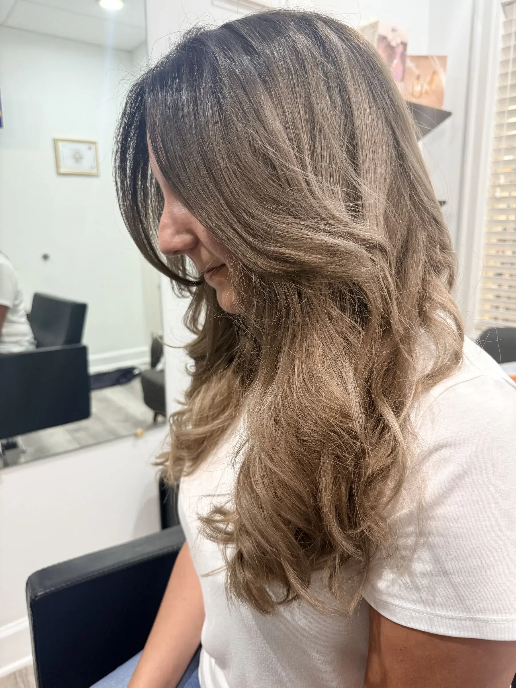 Ash bronde dimension through long layered waves, in profile
