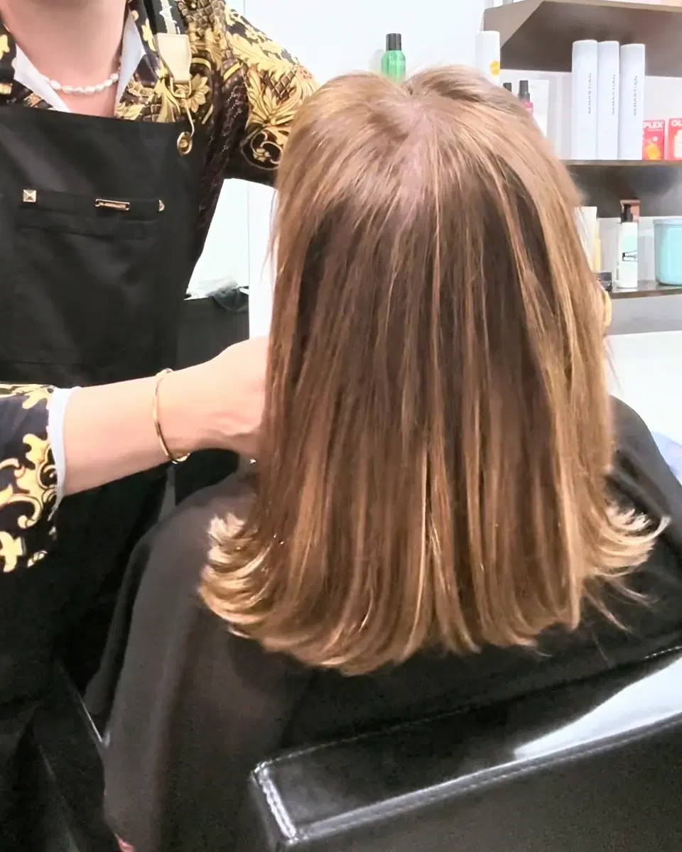 A soft caramel bob melting from a deep brown root, smooth and shoulder-length, with Rudy Perez beside it
