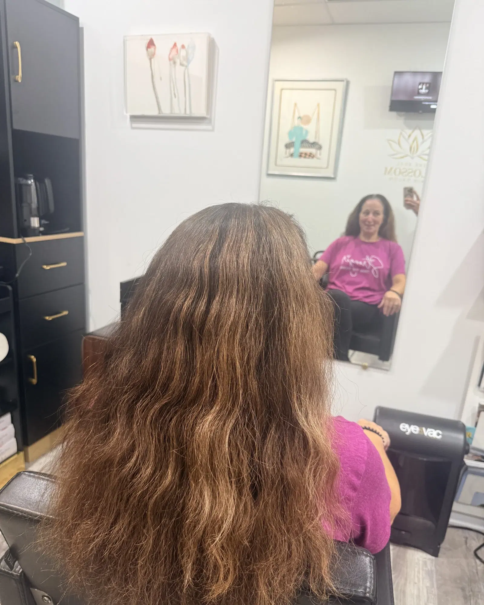 Long, brassy brown wavy hair before a balayage