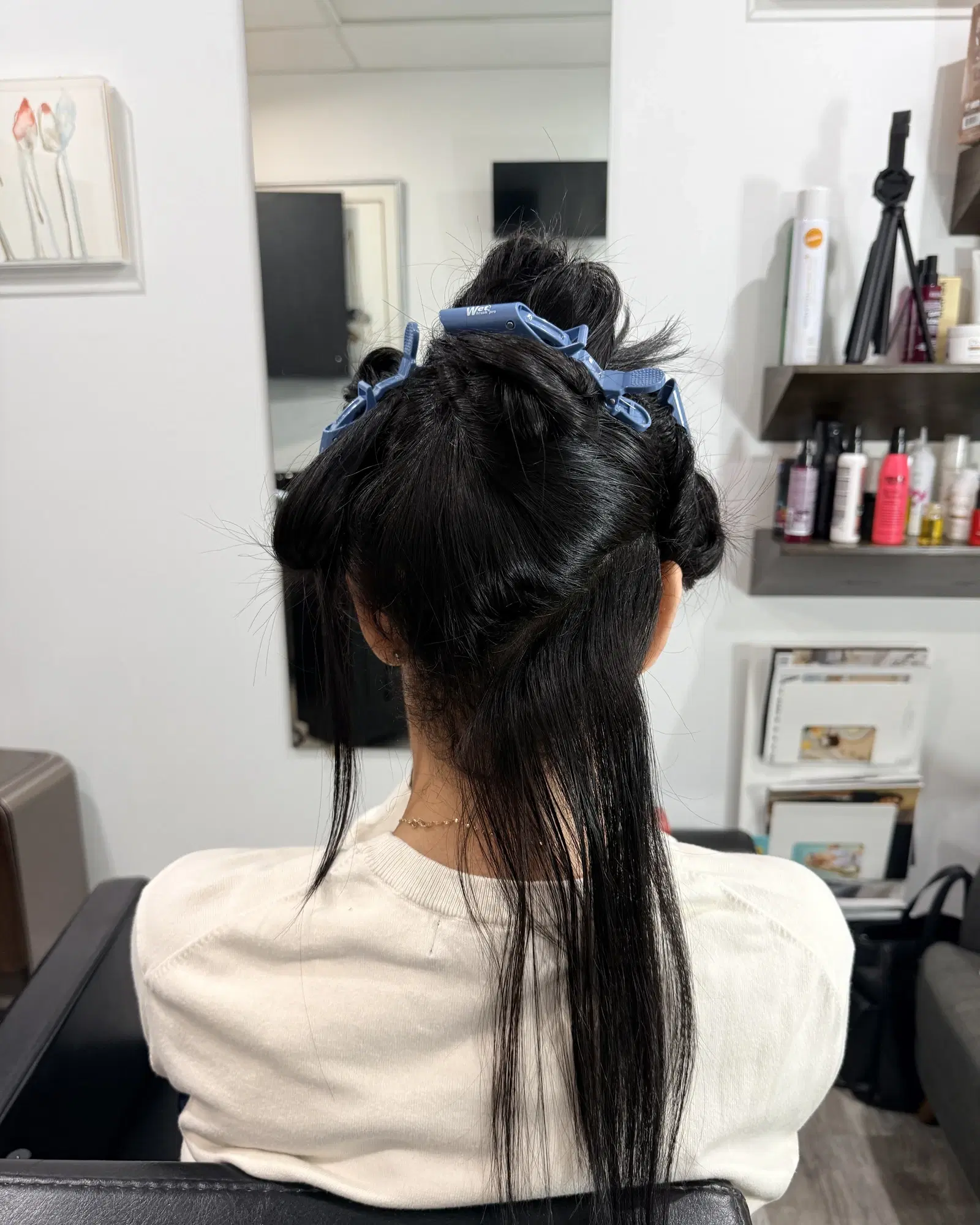 Long dark hair sectioned with clips before a cut