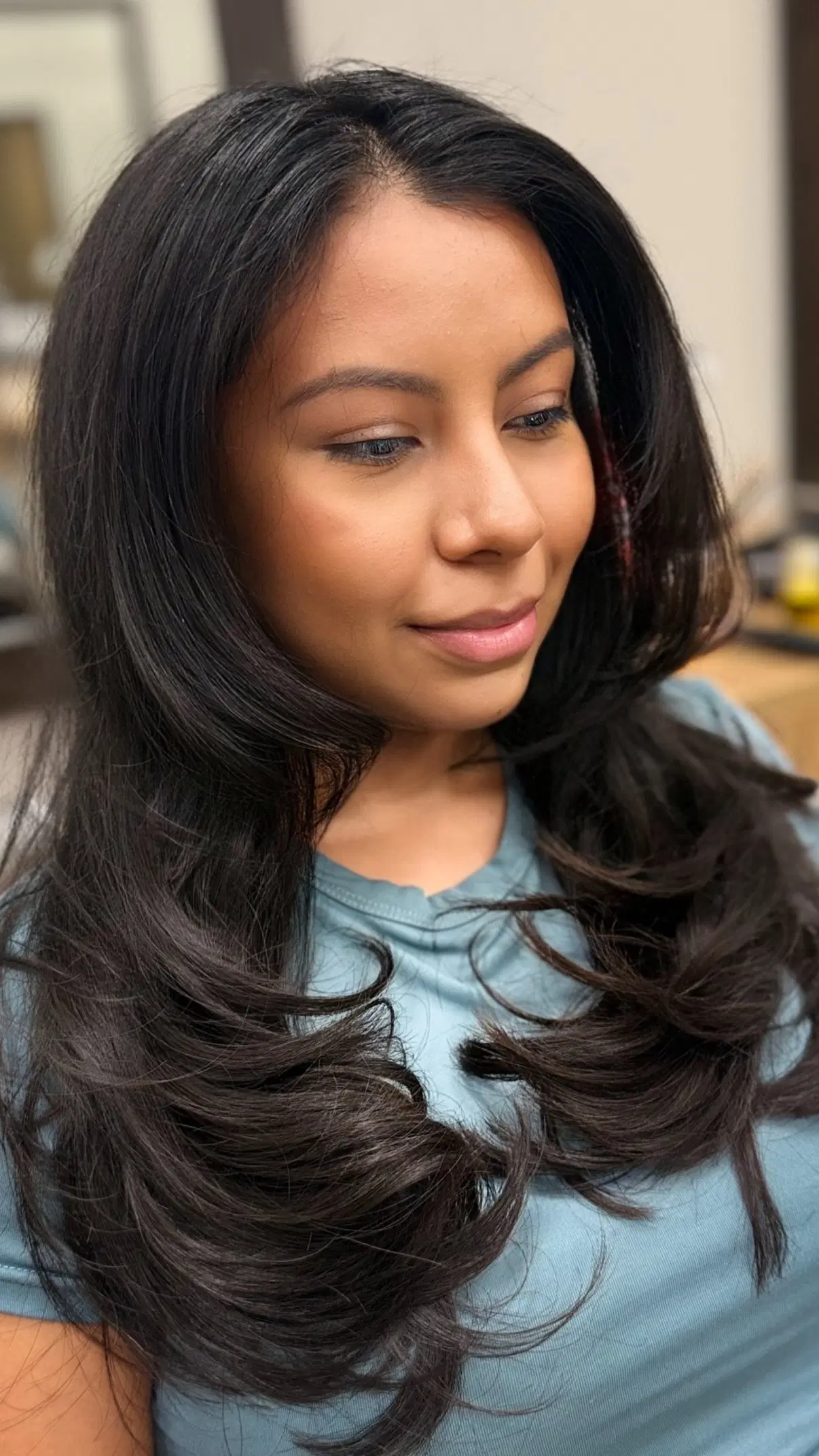 Long layered cut on dark hair, blown out with movement