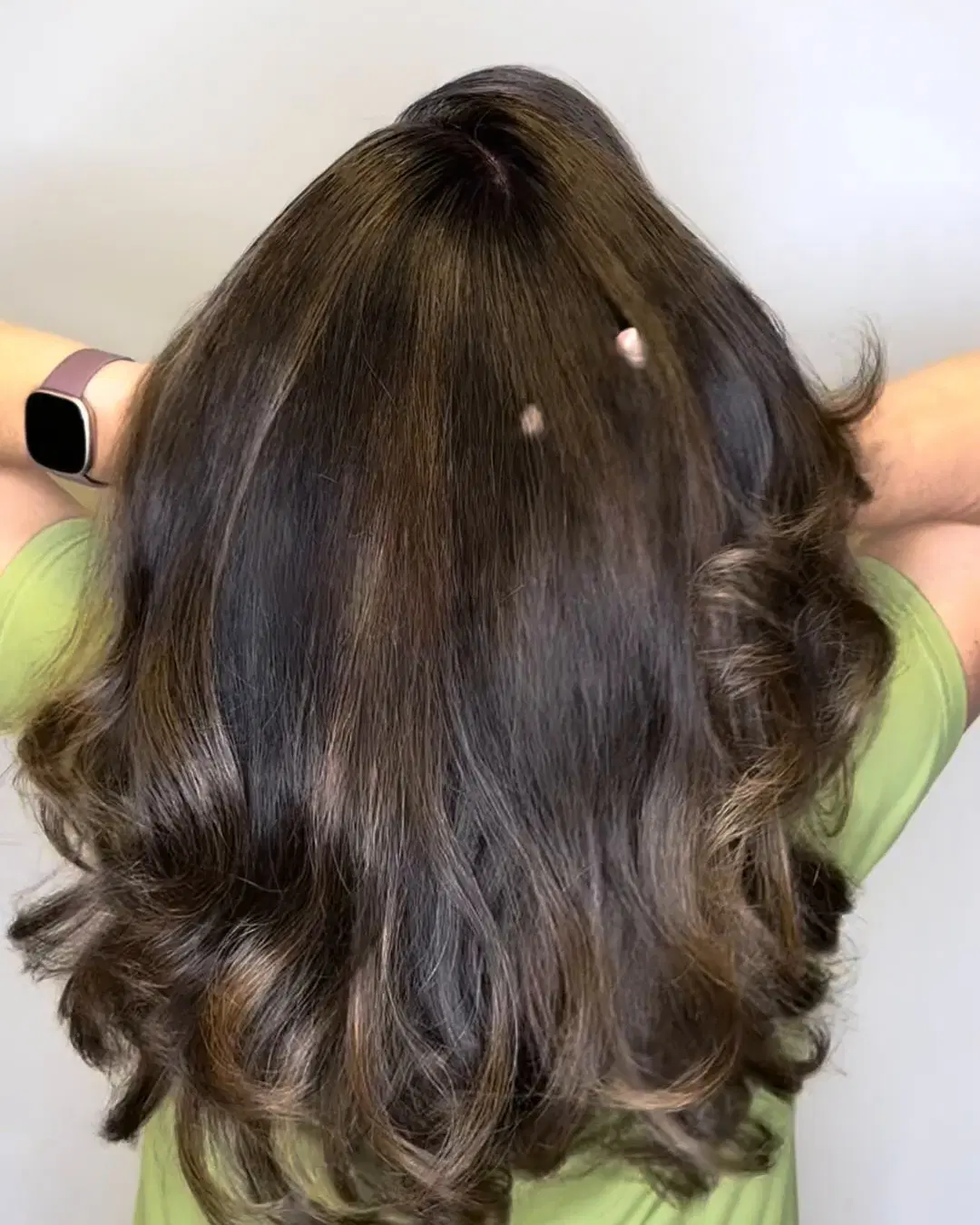Glossy brunette waves with soft caramel dimension